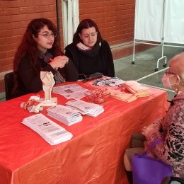 Estudiantes UCSH atienden en una mesa a adulta mayor.